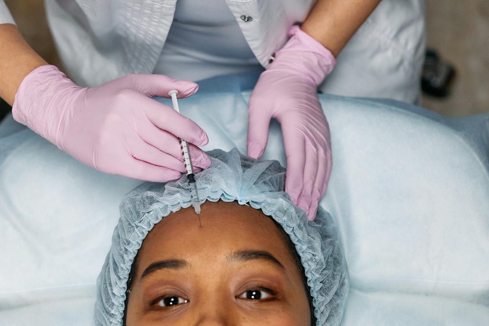 Close-up view of a botox injection being administered to a woman's forehead, representing modern cosmetology.